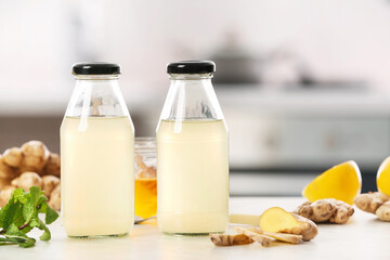 Bottles of healthy ginger juice on table in kitchen
