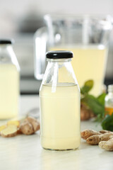 Bottle of healthy ginger juice on table