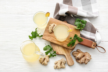 Composition with healthy ginger juice on white wooden background