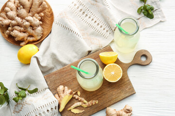 Composition with healthy ginger juice on white wooden background