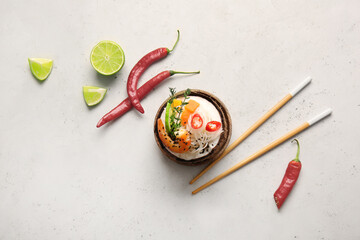 Fototapeta na wymiar Bowl with Thai noodle soup on light background