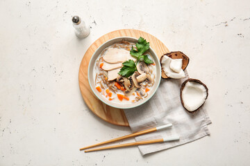 Bowl with Thai chicken noodle soup on light background