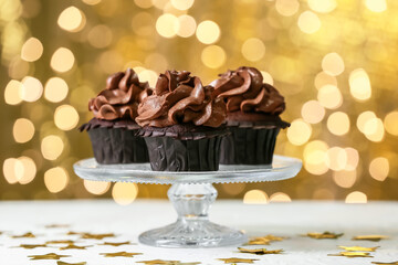 Dessert stand with chocolate cupcakes on blurred background