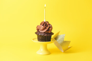Tasty chocolate cupcake with candle on color background