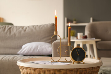 Aroma candles with alarm clock on table in room