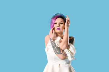 Portrait of extravagant stylish woman on color background