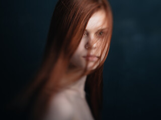 Portrait of a charming woman red hair bared shoulders close-up black background