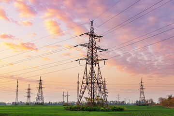 Power lines against sunset sky