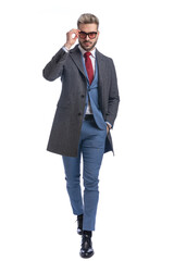 attractive young guy in elegant suit arranging glasses and walking