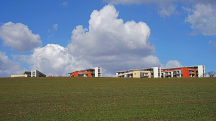 Fototapeta na wymiar Modern residential flat buildings located on empty meadow behind major city, new living concept