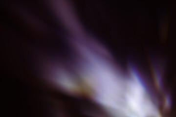 Blur colorful warm rainbow light leaks on black background with dust texture. Defocused abstract damaged scratched retro film analog effect for using over photos as overlay or screen filter