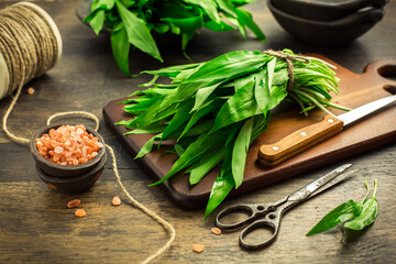 Bunch of Ramson or bear leek (Allium ursinum) with pink Himalayan salt on cutting board