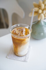 High angle view of Iced coffee latte is freshly drank in a glass on a white table