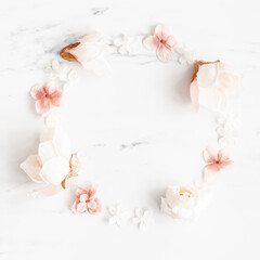 Flowers composition. Wreath made of white and pink flowers on marble background. Flat lay, top view
