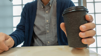 カップのコーヒーを持つ男性