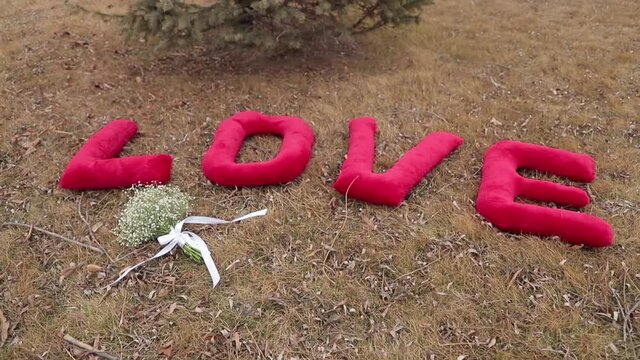 The letters "love" and a bridal bouquet on the ground.