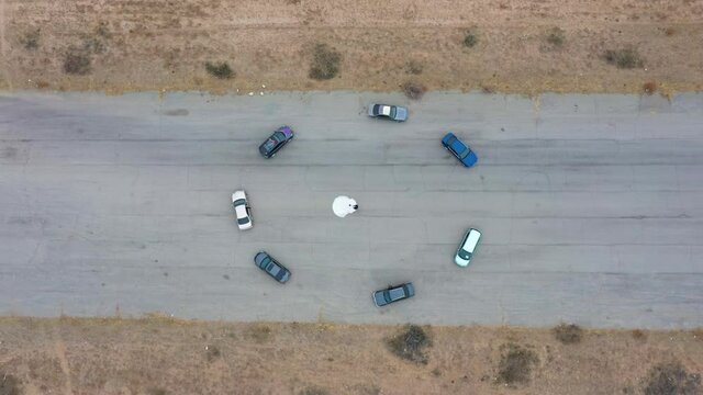 The cars are spinning in circles. In the center of the circle is the bride and groom. View from above.