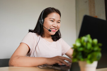 close up young asian woman call center talking on microphone headset to assist and consult...