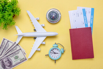 Layout of accessories for vacation and travel. Air tickets, money and documents on a yellow background
