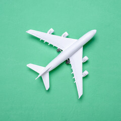 Miniature of an airplane on a green background with a copy space, top view. Concept of travel and vacation