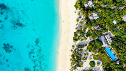 A bird's-eye view of the white sand beach and turquoise waters of the Indian Ocean.