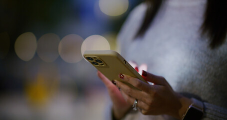 Woman use of mobile phone in city at night