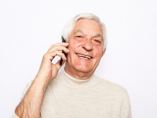 Technology, senior people, lifestyle and communication concept - close up of happy old man using smartphone over white background.