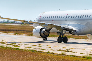 Big passenger airplane drives along the runway in airport