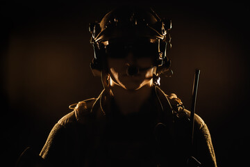 Portrait of special forces soldier in helmet and glasses in the dark