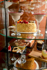 Dessert stand in cafe. Glass stand with different cakes and desserts, sweet food. Eating out concept
