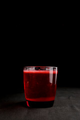 Refreshing fruit punch beverage in glass over black background. Isolated on black.
