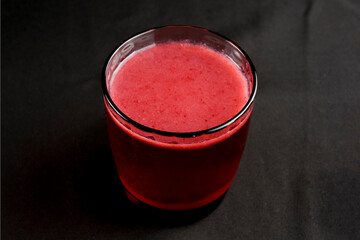 Refreshing fruit punch beverage in glass over black background. Isolated on black.