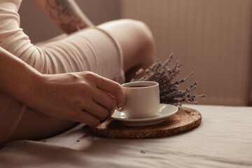 Very pretty redhead girl with dreads on bed in bedroom in the morning. A feminine, gentle girl. Coffee morning concept.