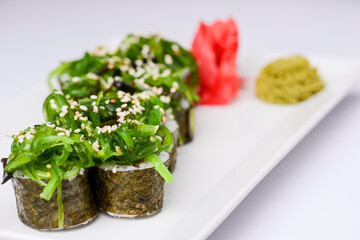 Sushi small set served on a white plate over white background. Traditional Asian Japanese cuisine concept.