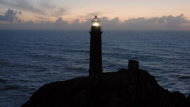 Lit lighthouse at dusk in Cape Vilan Galicia Spain Aerial view