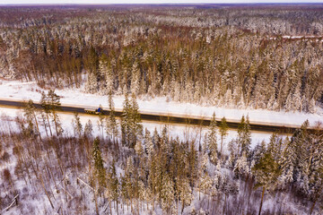 Direct road through the winter forest. View from above