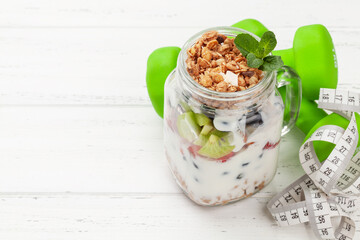 Healthy breakfast with jar of granola, yogurt and fresh berries