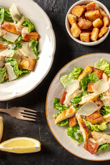Chicken Caesar salad, shot from the top with croutons and lemons