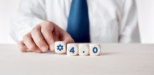 Businessman places the wooden cubes with the word Industry 4.0