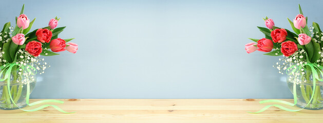 spring bouquet of red and pink tulips flowers in the glass vase over wooden table