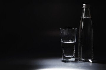 Close up pouring purified fresh drink water from the bottle on table in living room. Drinking water. Mineral vitamin water. Healthy, mineral-rich, refreshing water.