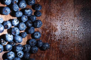 Water drops on ripe sweet blueberry. Fresh blueberries background with copy space for your text. Vegan and vegetarian concept. Macro texture of blueberry berries.