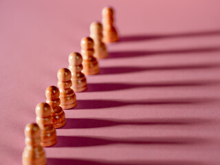 chess pieces in a row, white pawns on a pink background,