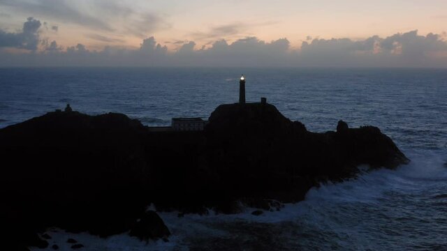 Lit lighthouse at dusk in Cape Vilan Galicia Spain Aerial view
