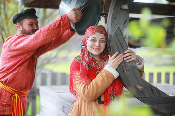 Traditional Slavic rituals in the rustic style. Outdoor in summer. Slavic village farm. Peasants in elegant robes.