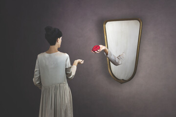 surreal gesture of a hand coming out of the mirror to give a rose to a woman