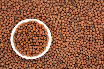 Organic dried carlin peas in a white porcelain bowl & forming an abstract background. Very high in protein, low in fat, high in fibre, antioxidants & anthocyanins. Flat lay, top view.