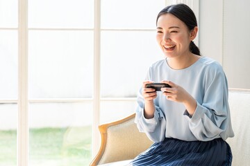部屋でゲームをする若いアジア人女性
