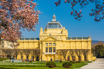 Fototapeta premium Colorful magnolia blossom and monumental architecture in spring in Zagreb, Croatia