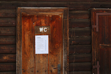 Hygiene tips at wooden WC door during Covid-19 pandemic in German
